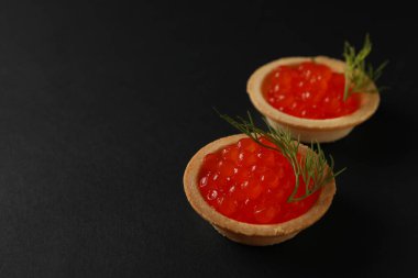 Siyah arkaplanda havyarlı tartlar, metin için boşluk