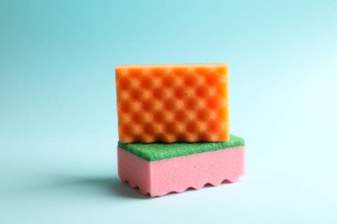 Mavi arkaplanda temizlik için renkli süngerler