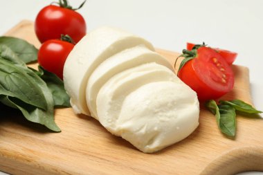 Beyaz arka planda mozzarella peyniri, domates ve fesleğen.