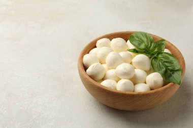 Beyaz desenli arka planda mozzarella ve fesleğenli kase, metin için boşluk