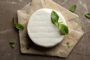 Gri arka planda peynirli ve fesleğenli fırın kağıdı.