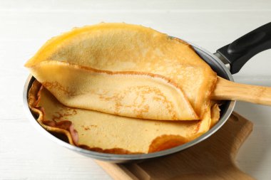 Lezzetli ince krepli tava ve ahşap masada spatula.