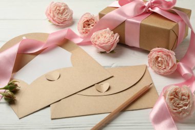 Hediye kutusuyla 8 Mart konsepti ve beyaz ahşap arka planda zarflar