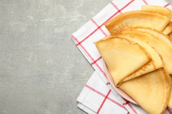 Küchentuch Mit Teller Mit Dünnen Pfannkuchen Auf Grauem Tisch — Stockfoto