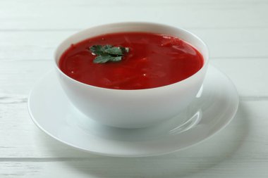 Beyaz ahşap arka planda bir kase borş çorbası
