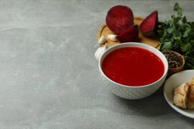 Borş çorbası ve gri masadaki malzemelerle lezzetli yemek kavramı.