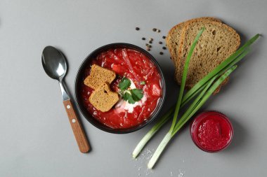 Borş çorbası ve gri masadaki malzemelerle lezzetli yemek kavramı.