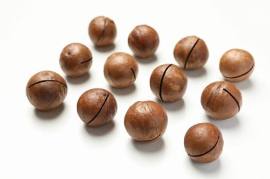 Beyaz arka planda lezzetli macadamia fındıklarıyla yatıyordu.