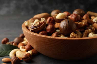 Gri ahşap arka planda farklı fındıklı ahşap kase.