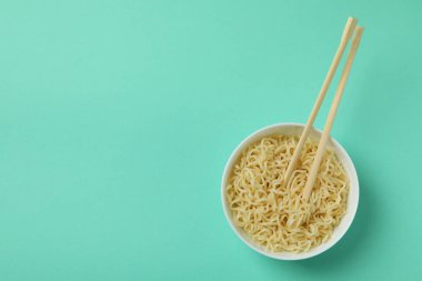 Nane arkaplanda erişte ve çubuklarla dolu bir kase.