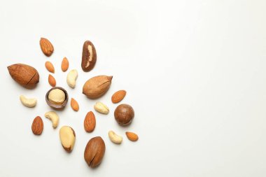 Beyaz arkaplanda farklı lezzetli fındıklar, metin için boşluk