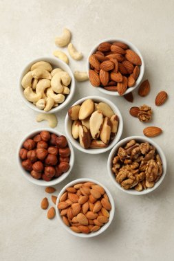 Beyaz desenli arka planda farklı fındıklı kaseler, üst görünüm