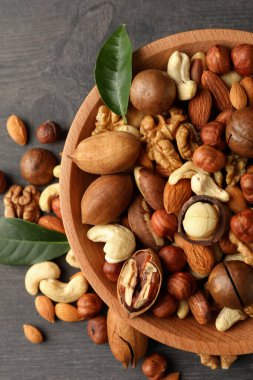 Gri ahşap arka planda farklı fındıklı ahşap kase.