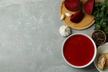 Borş çorbası ve gri masadaki malzemelerle lezzetli yemek kavramı.