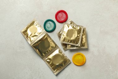 Beyaz desenli arka planda çok renkli prezervatifler, üst görünüm