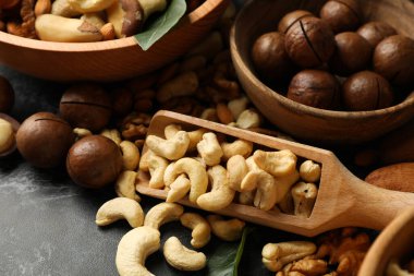 Siyah dumanlı arka planda farklı fındıklı kase ve ahşap kepçe