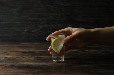 Votka ya da ahşap arka planda limonlu tekila.