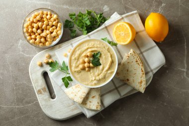 Gri arka planda bir kase humus ile lezzetli yemek kavramı