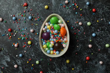 Çikolatalı yumurtanın yarısı şekerli ve siyah dumanlı arka planda serpiştirilmiş.