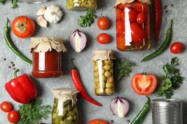 Gri arka planda farklı konserveler ve malzemeler vardı.