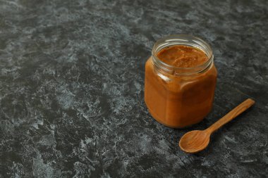 Kabak havyarlı kavanoz ve siyah dumanlı arka planda tahta kaşık.