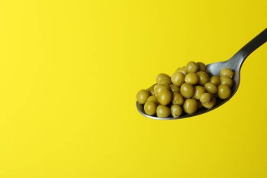 Sarı arka planda bezelyeli kaşık.