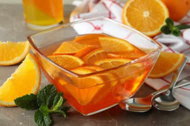 Gri masadaki portakal dilimli turuncu jöleli tatlı kavramı.