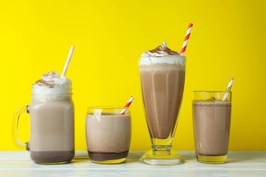 Sarı arka planda çikolatalı milkshake bardakları