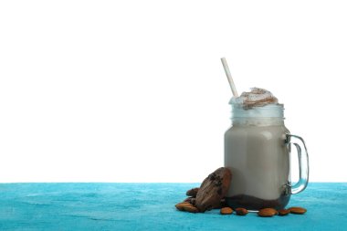 Çikolatalı milkshake, kurabiyeler ve badem mavi desenli masa beyaz arka planda izole.