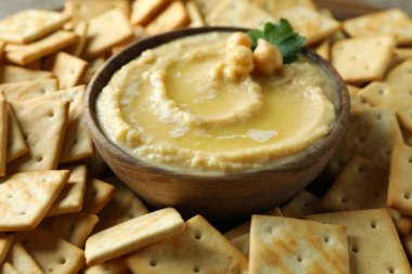 Kraker arka planında bir kase humus, kapatın.