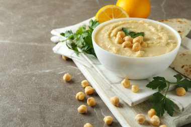 Gri arka planda bir kase humus ile lezzetli yemek kavramı