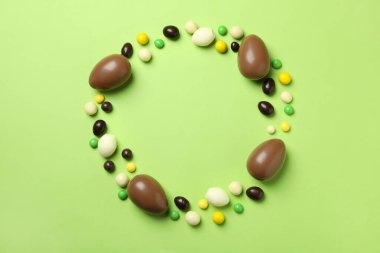 Yeşil arka planda Paskalya çikolataları ve şekerler