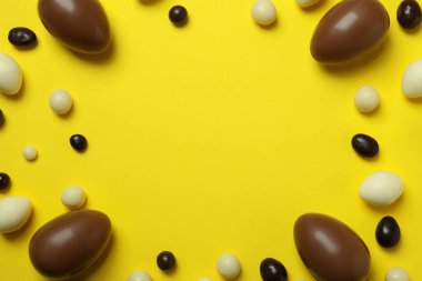 Sarı arka planda Paskalya çikolatası ve şeker.