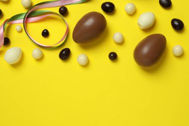 Sarı arka planda Paskalya çikolatası ve şeker.