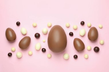 Paskalya çikolatası ve pembe arka planda şekerler.