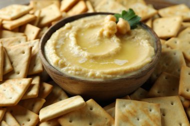 Kraker arka planında bir kase humus, kapatın.