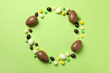 Yeşil arka planda Paskalya çikolataları ve şekerler