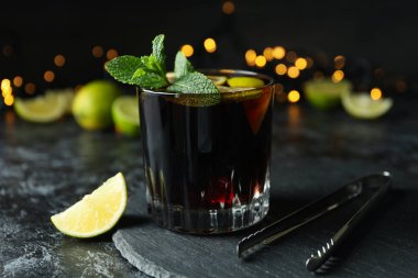 Bulanık ışıklara karşı bir bardak Küba Libre kokteyli.