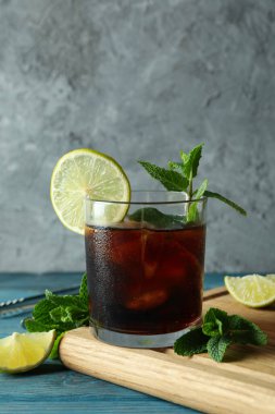 Tahta masanın üzerinde bir bardak Küba Libre 'si olan bir tahta.