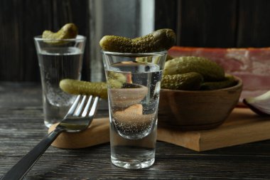 Votka ve lezzetli atıştırmalıklar ahşap masada.