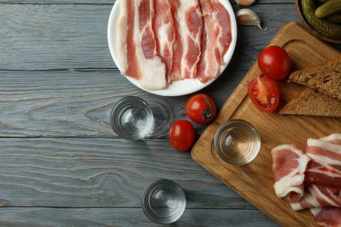 Gri ahşap arka planda votka ve lezzetli atıştırmalıklar.