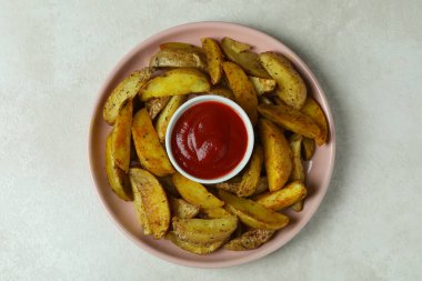 Beyaz desenli arka planda kızarmış patates ve sos tabağı.