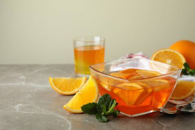 Gri masadaki portakal dilimli turuncu jöleli tatlı kavramı.