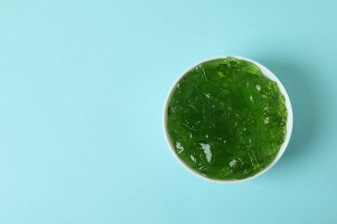 Mavi arka planda bir kase kivi jölesi.