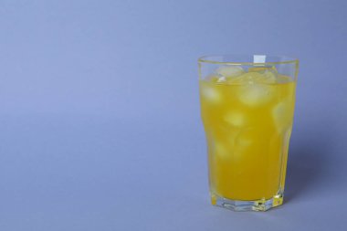 Bir bardak portakallı soda ve menekşe arkaplanda buz.