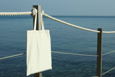 Deniz kıyısındaki iskelede boş bir çevre çantası.