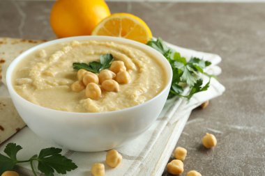 Gri arka planda bir kase humus ile lezzetli yemek kavramı