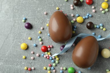 Paskalya çikolatası yumurtaları ve gri arka planda şekerler