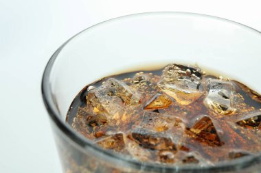 Beyaz arka planda bir bardak kola ve buz.