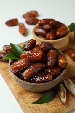 Beyaz zemin üzerinde kurumuş tarihler bulunan tahta